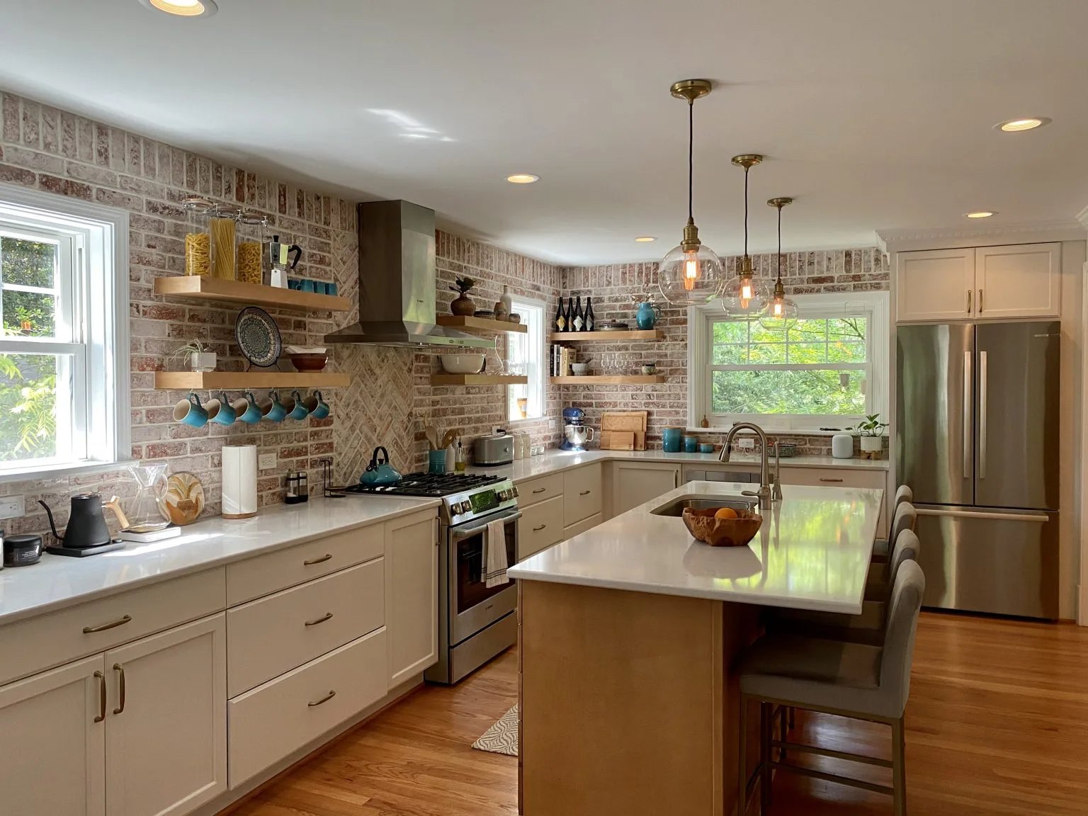 Versatile Edge kitchen craftsmanship with brick, brass, and custom shelving
