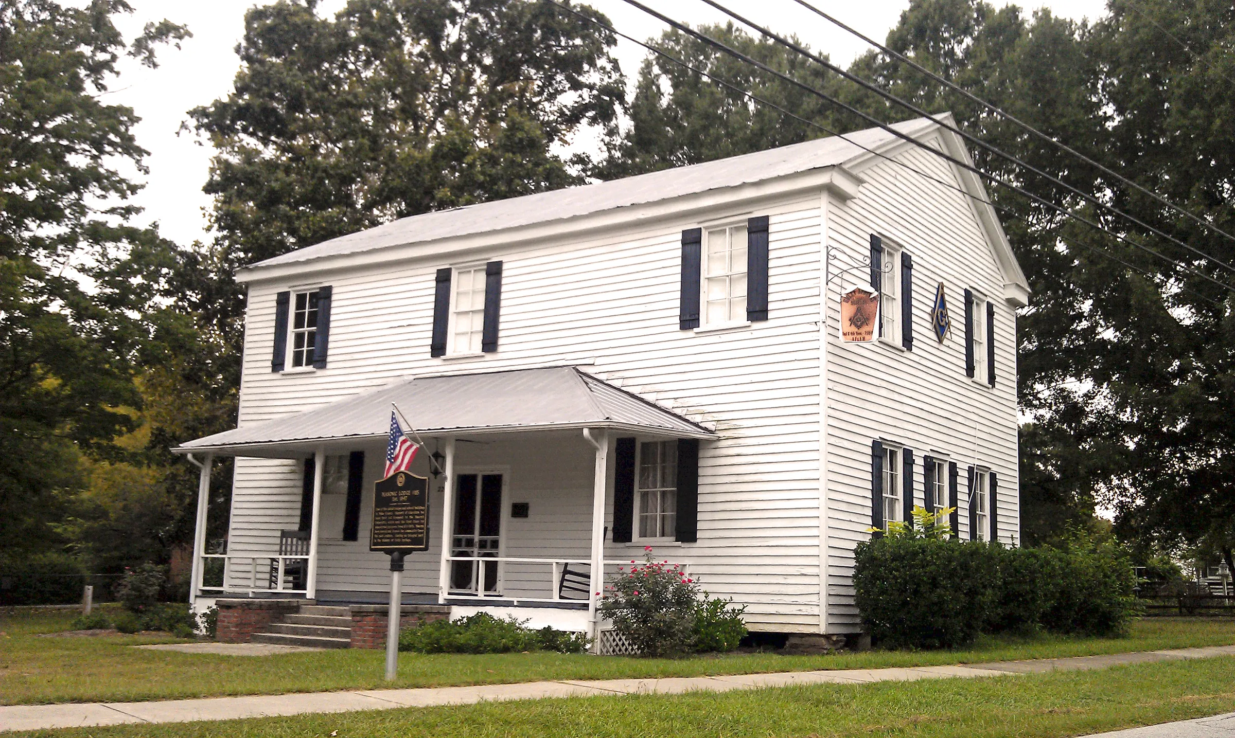 Historic Holly Springs Masonic Lodge with white porch and brick chimneys