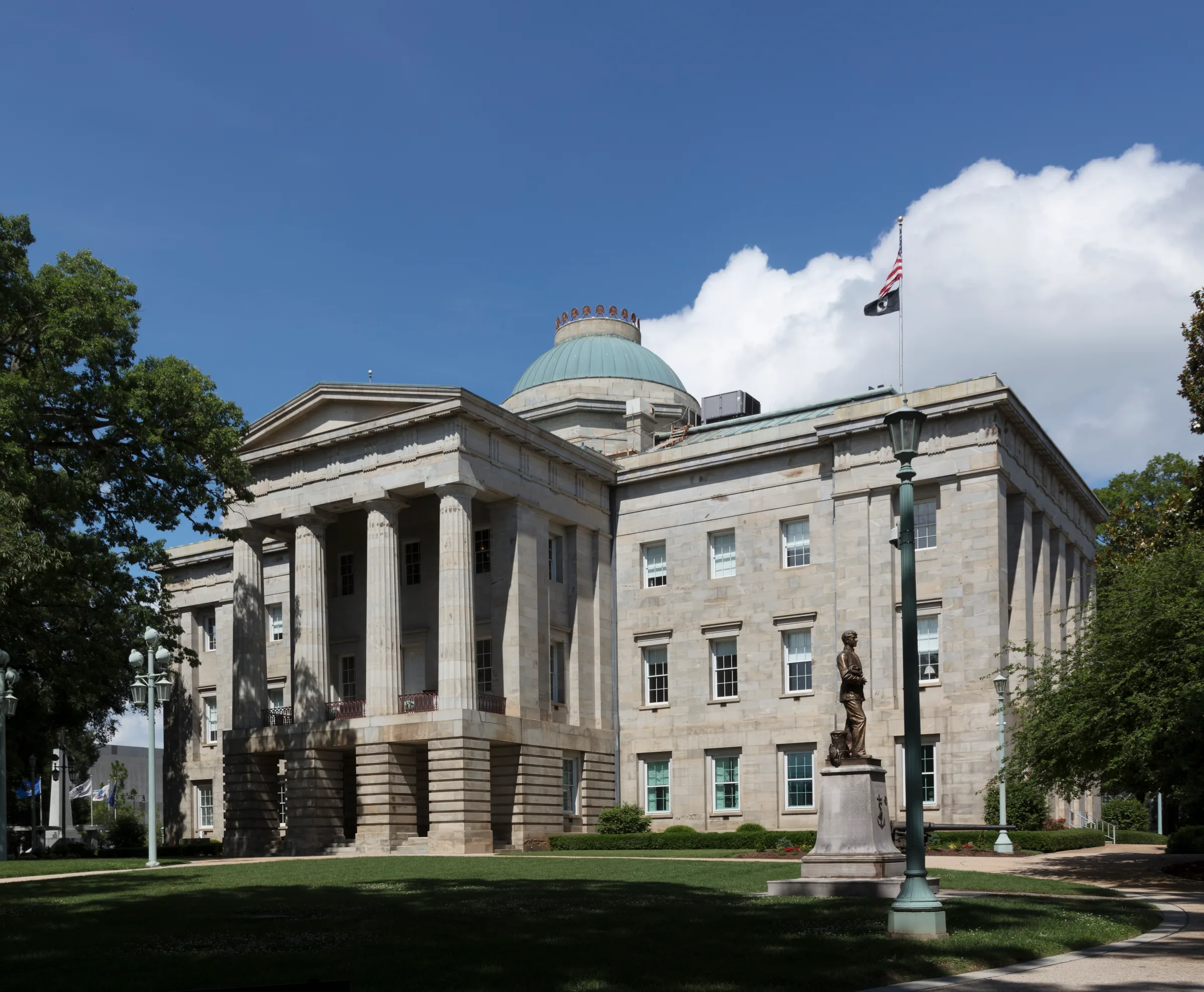 North Carolina State Capitol framed by trees in downtown Raleigh